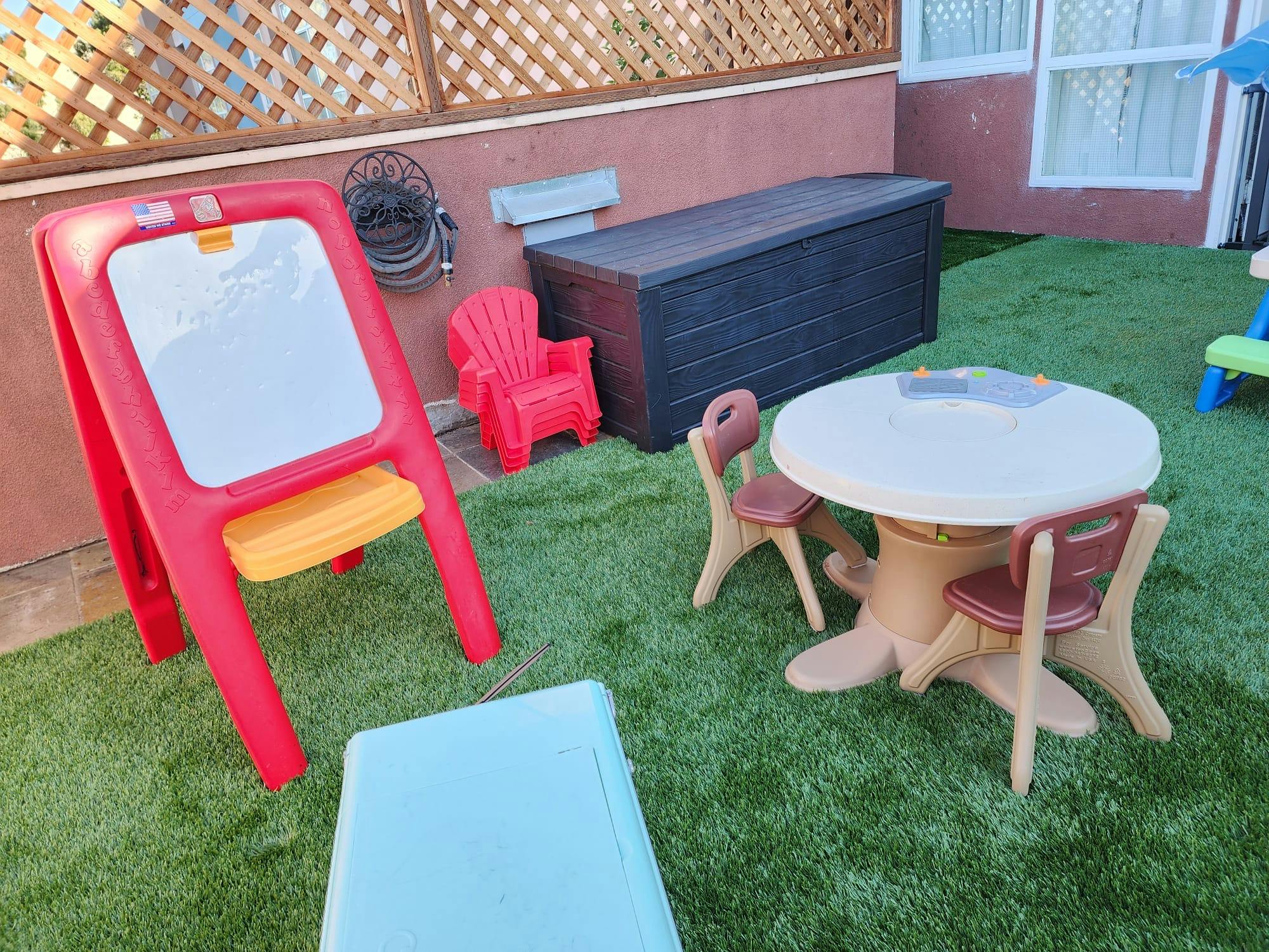 Children's easel, table, and chairs on artificial grass