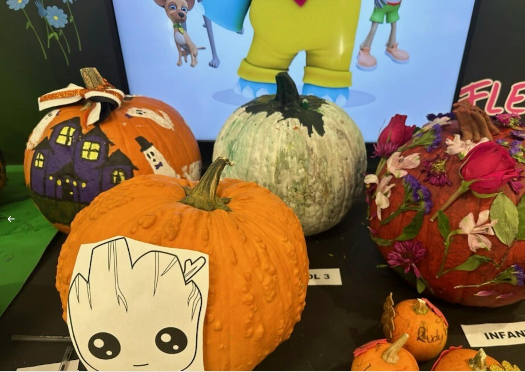 Decorated pumpkins, including one with a haunted house and another with flowers