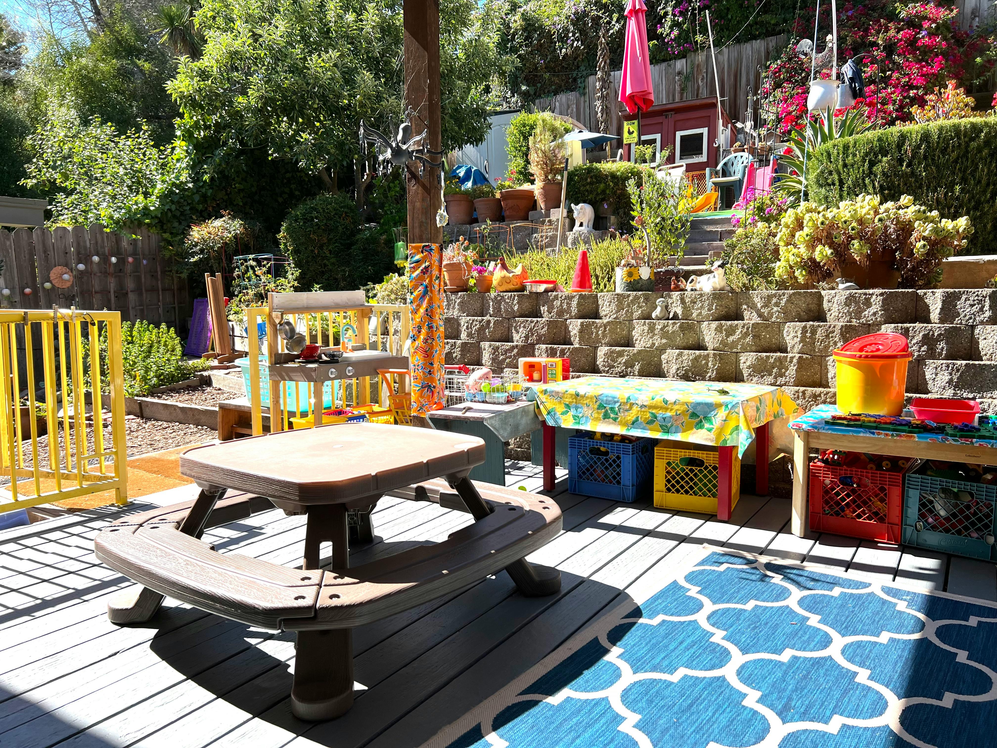 Outdoor patio with a small picnic table and play area