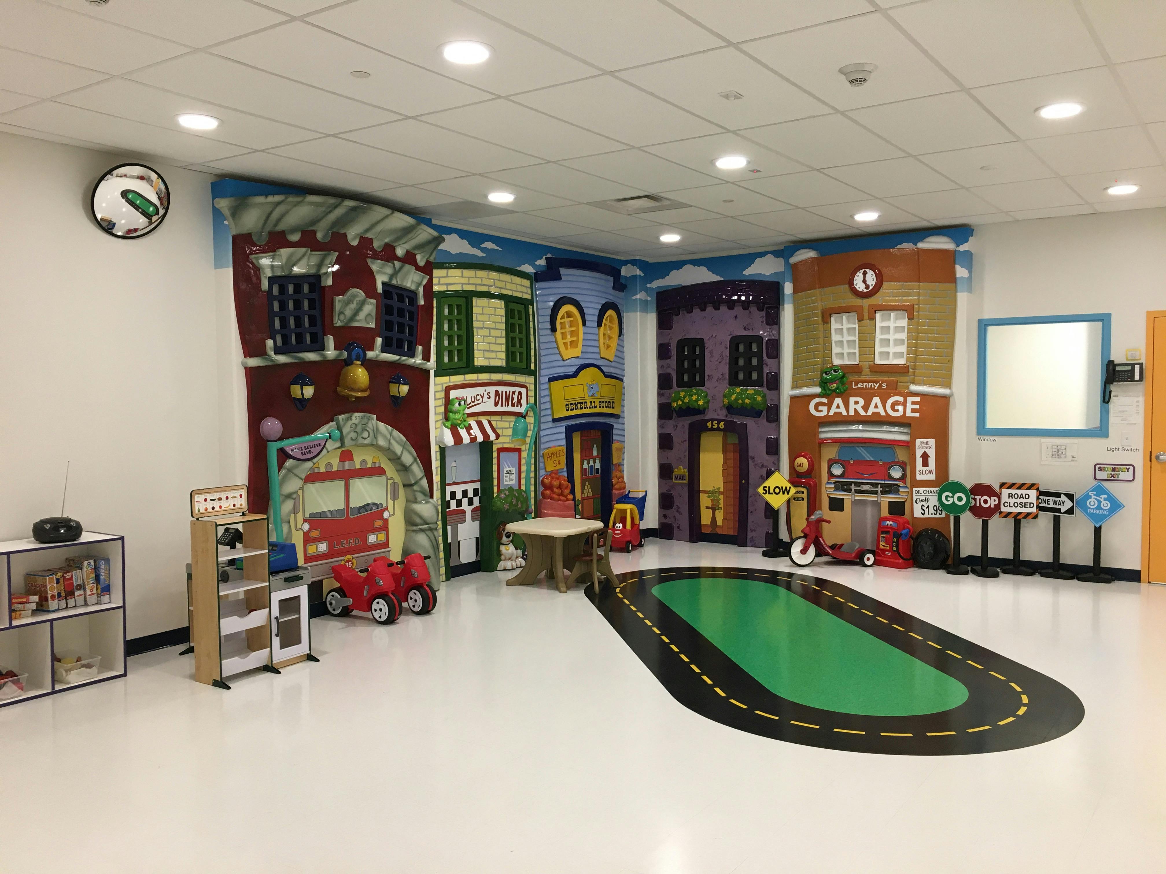 Playroom with city-themed wall murals and a road rug