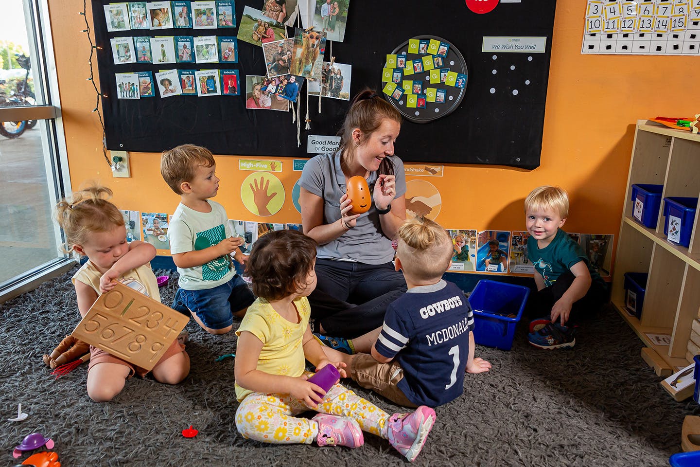 Adult and children sitting on floor in classroom