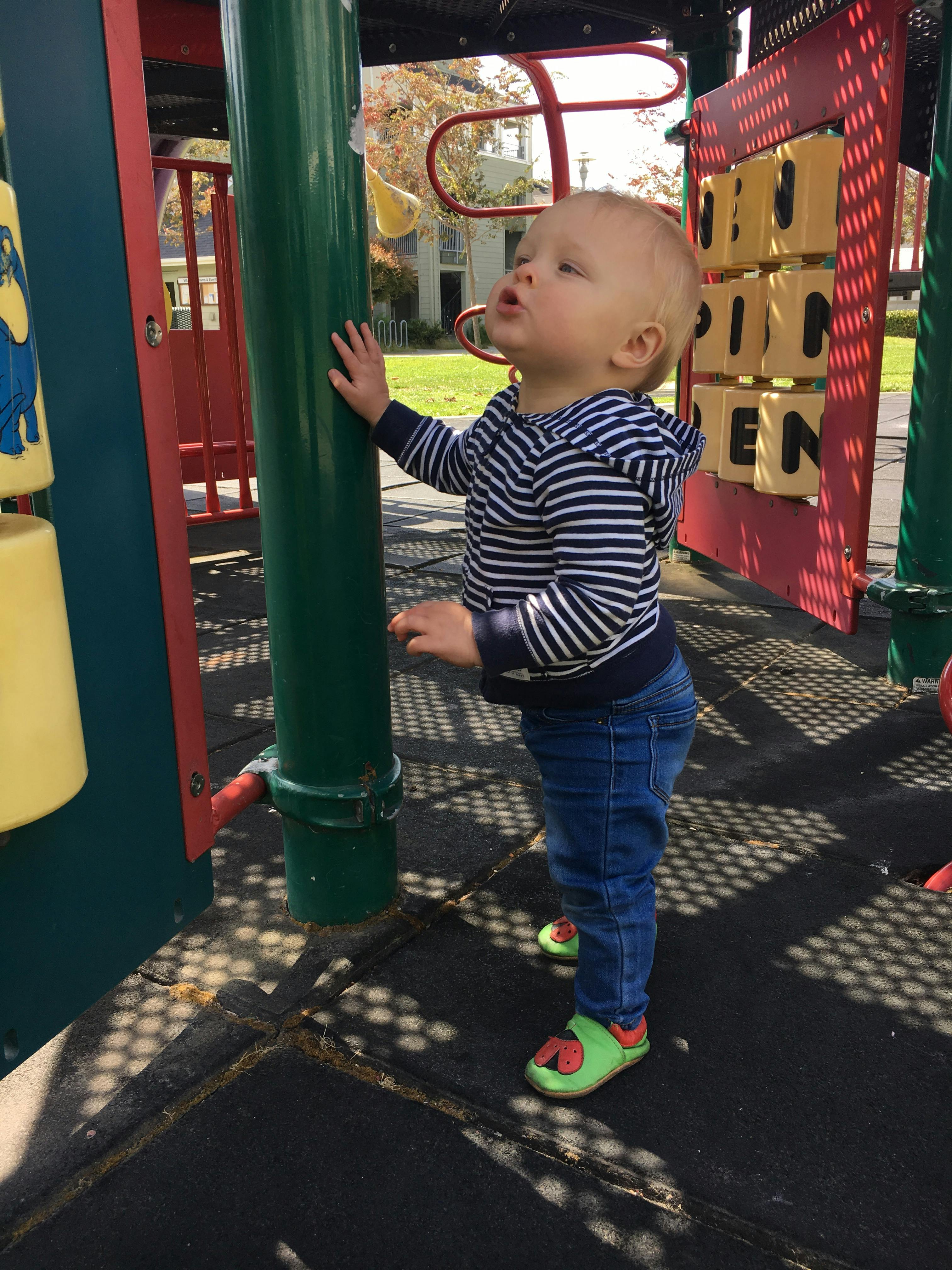 Child in striped hoodie and jeans on a playground