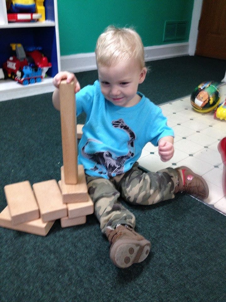 Child playing with wooden blocks on the floor