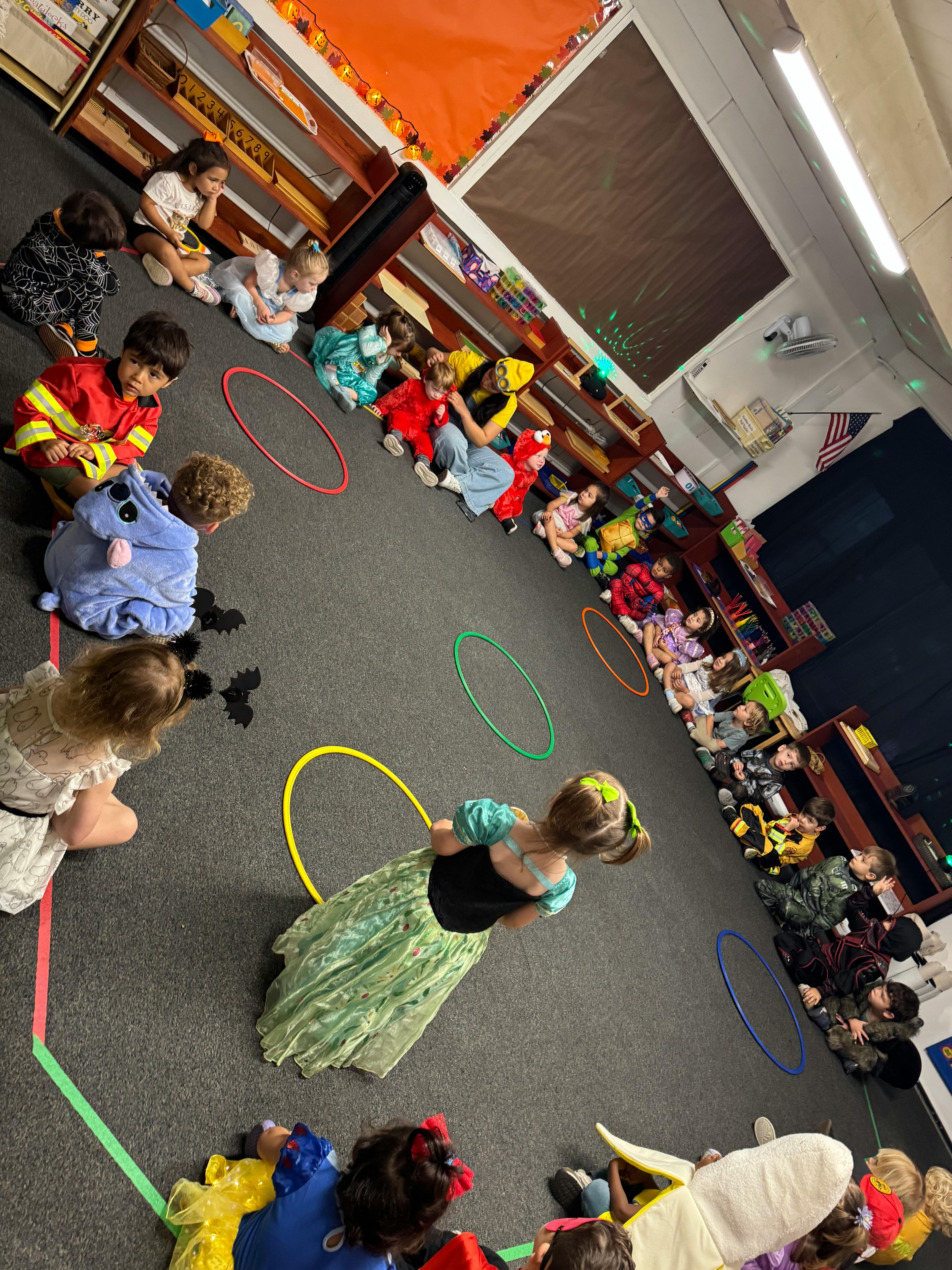 Children in costumes sitting in a circle in a classroom
