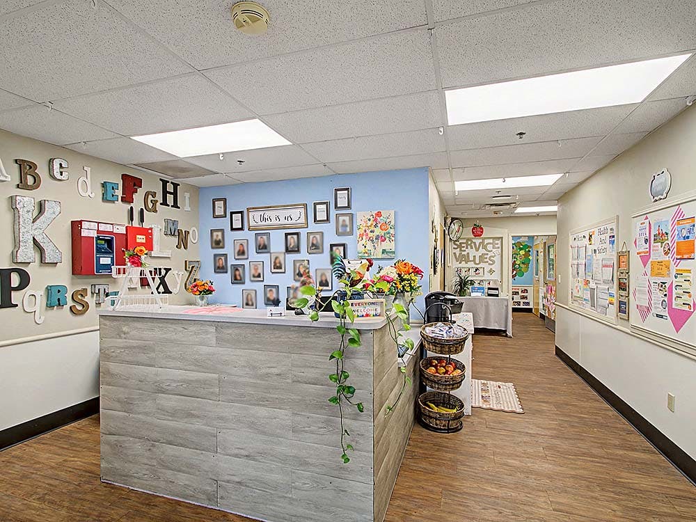 Reception desk with alphabet letters on the wall and a hallway