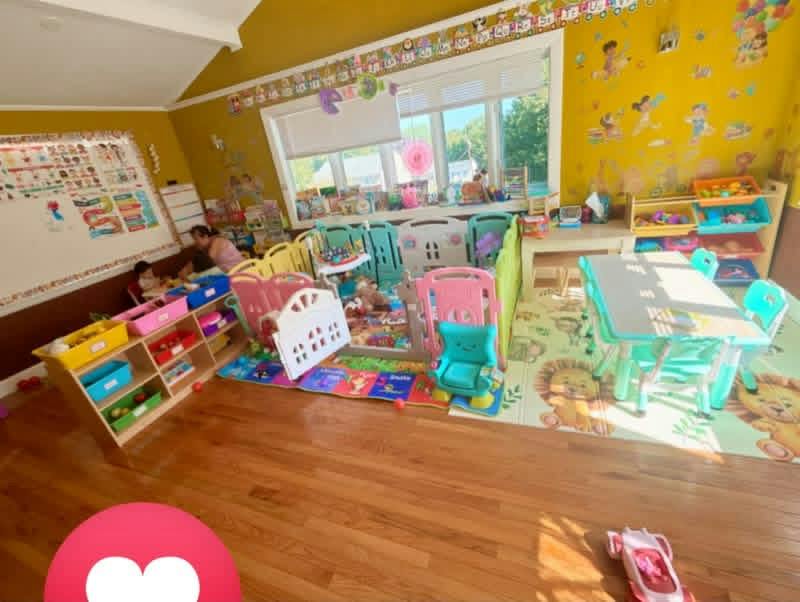 Colorful indoor play area with toy storage, child-sized tables, and floor mats