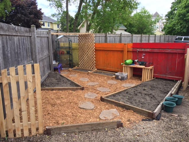 Raised garden beds with wood chip paths and stepping stones