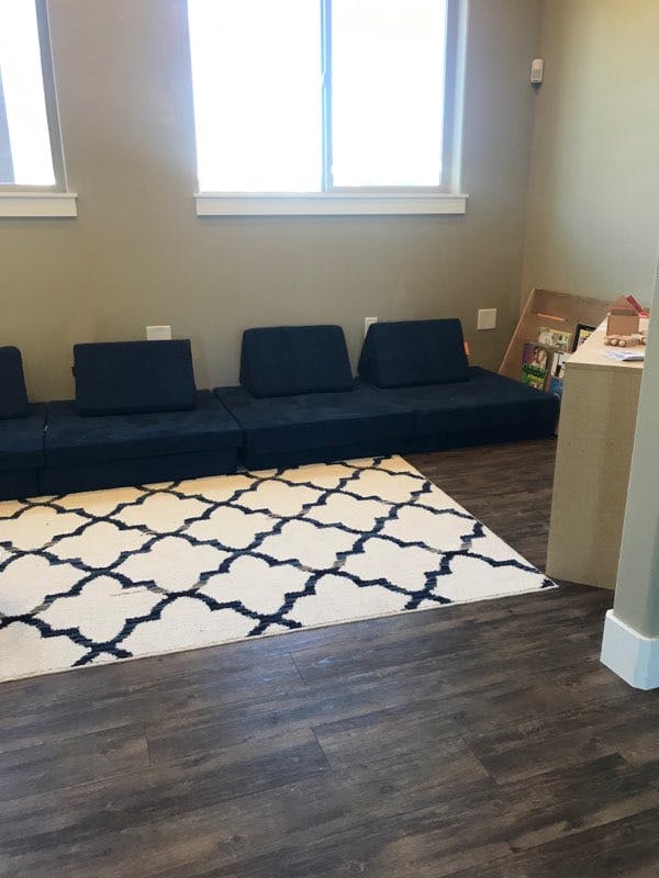 Floor seating with a patterned rug in a room with windows