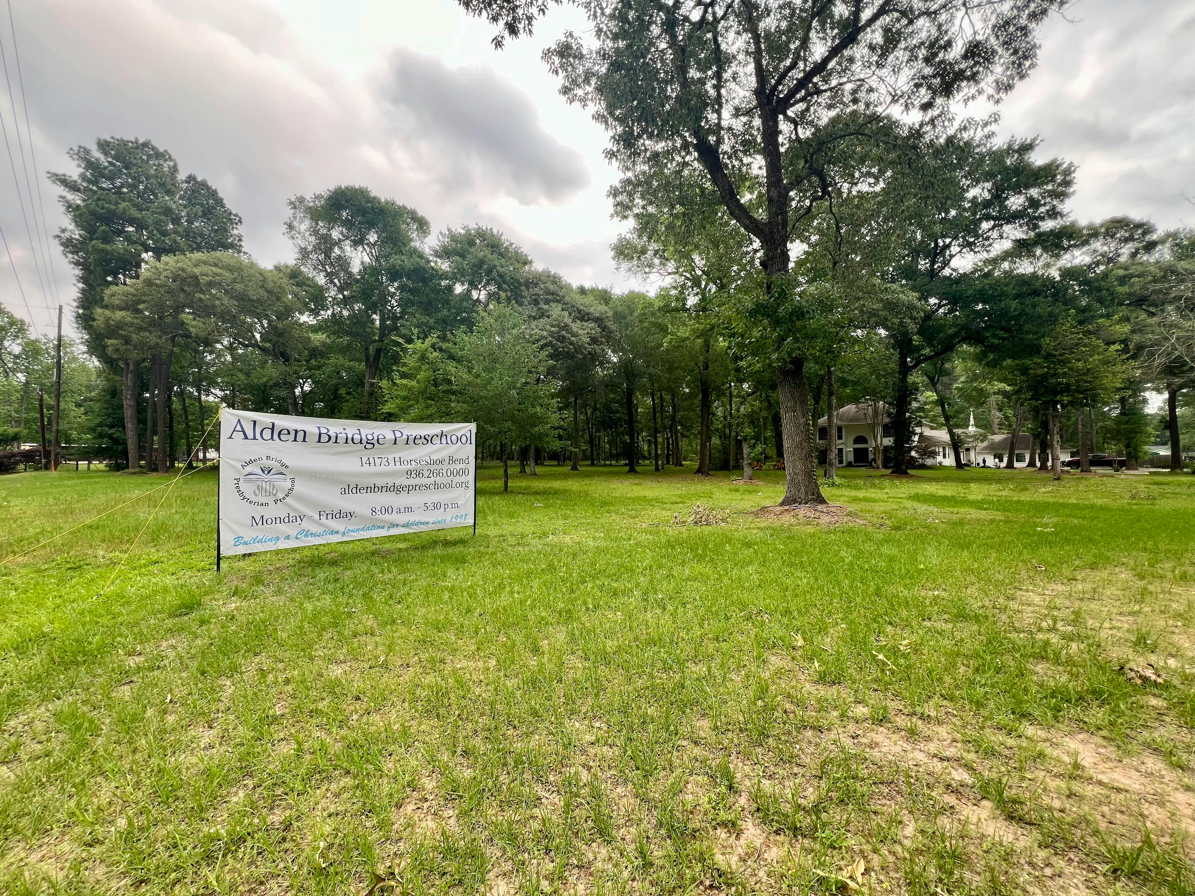 White banner in a grassy field with trees in the background