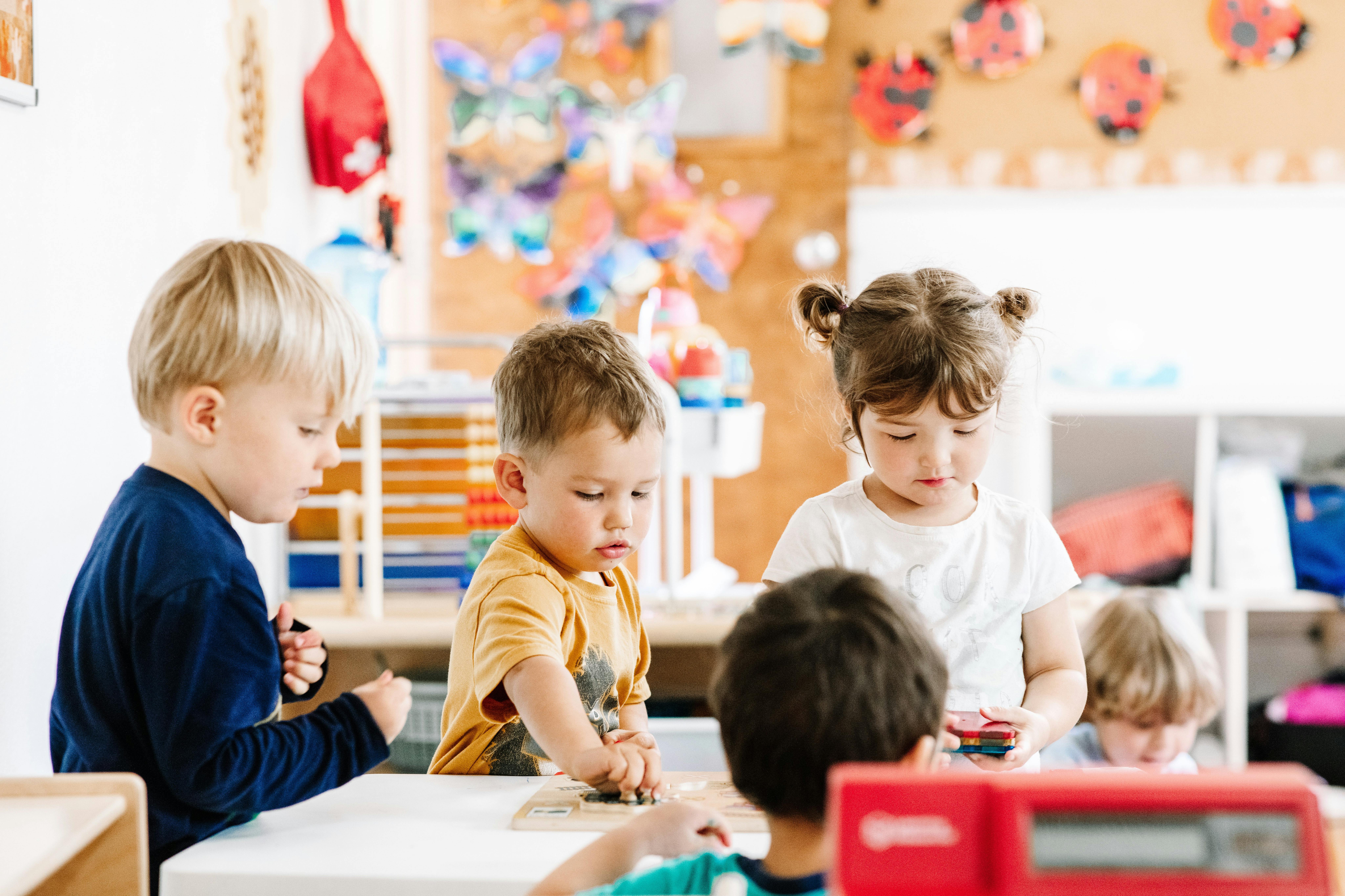 Children playing at a table in a classroom