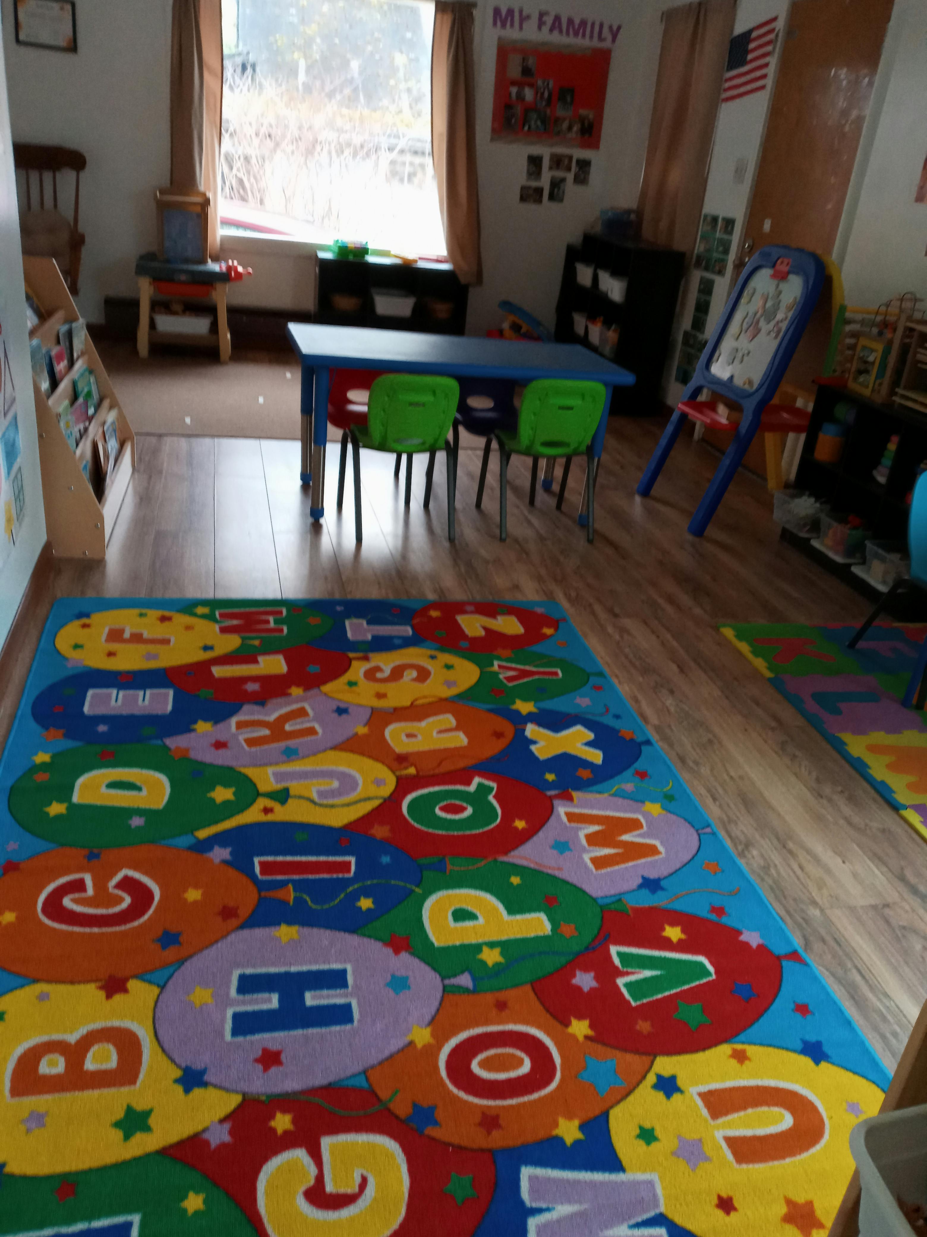 Classroom with an alphabet rug, small table, and chairs