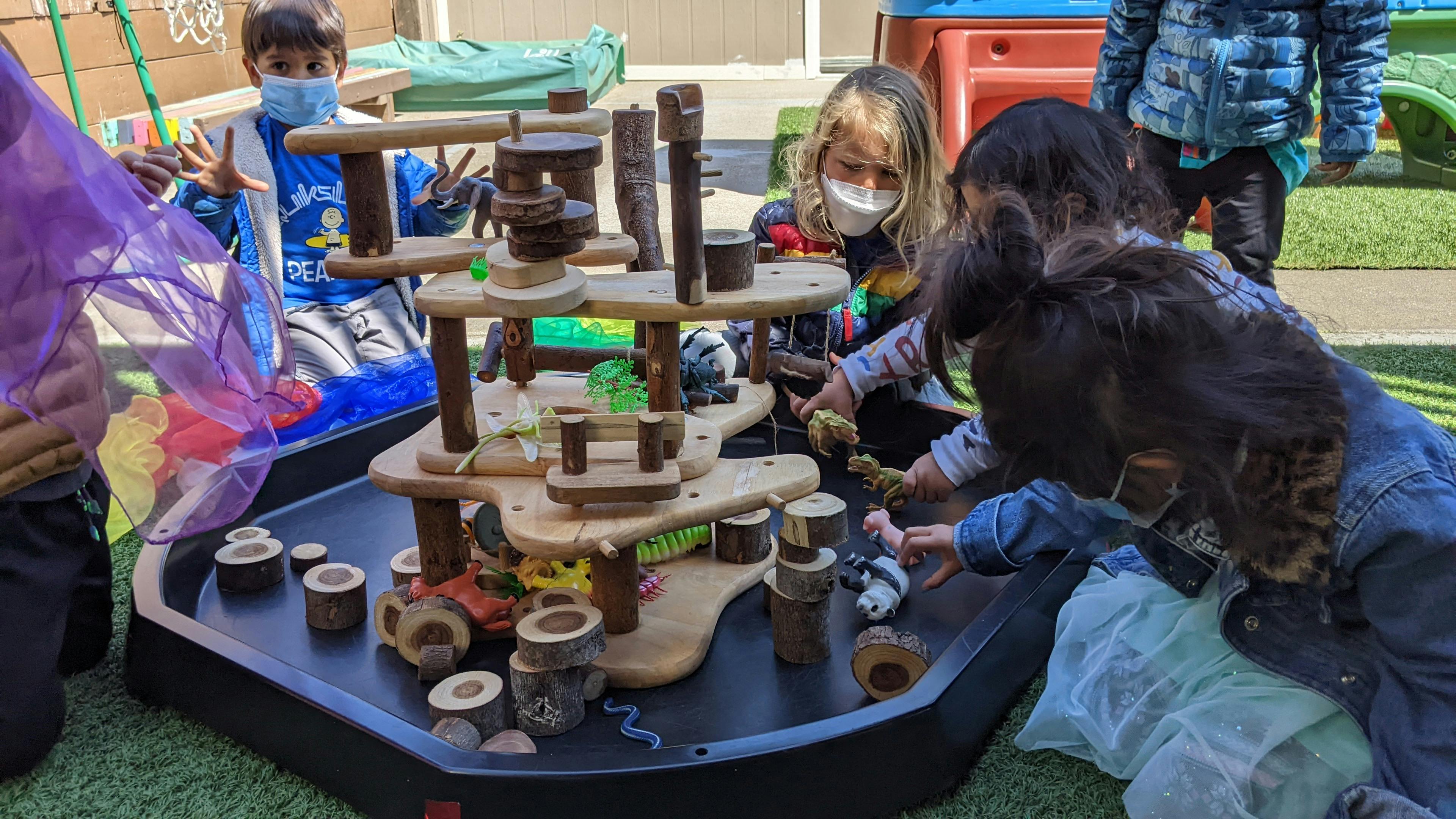 Children playing with a wooden block structure