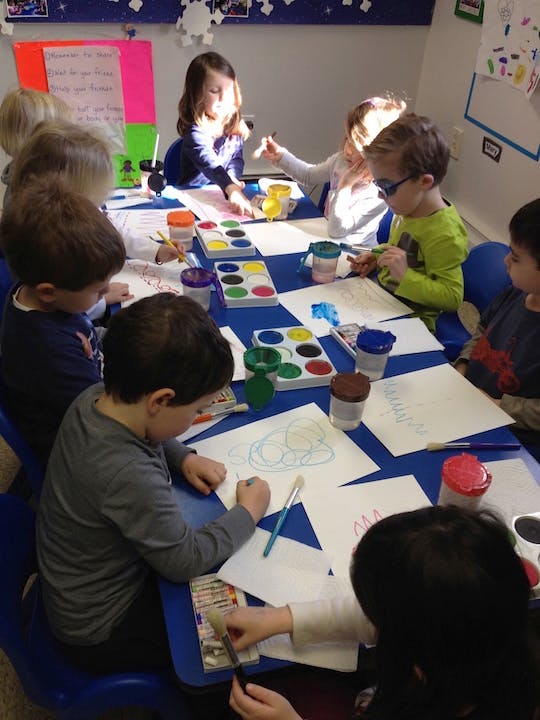 Children painting and drawing at a table