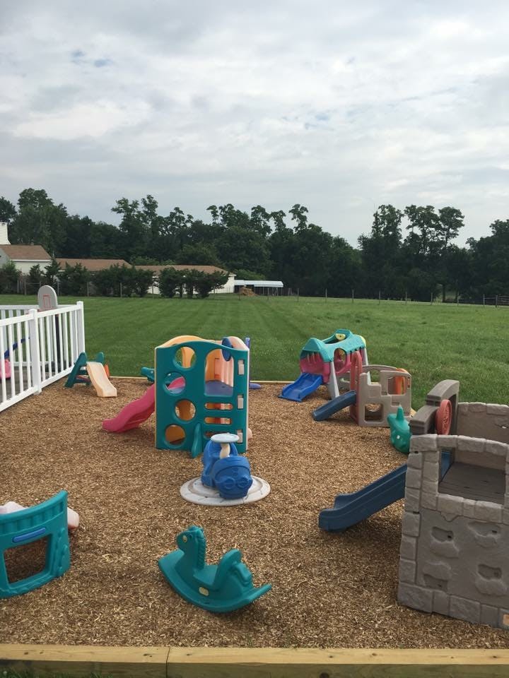 Outdoor playground with various colorful play structures on wood chips