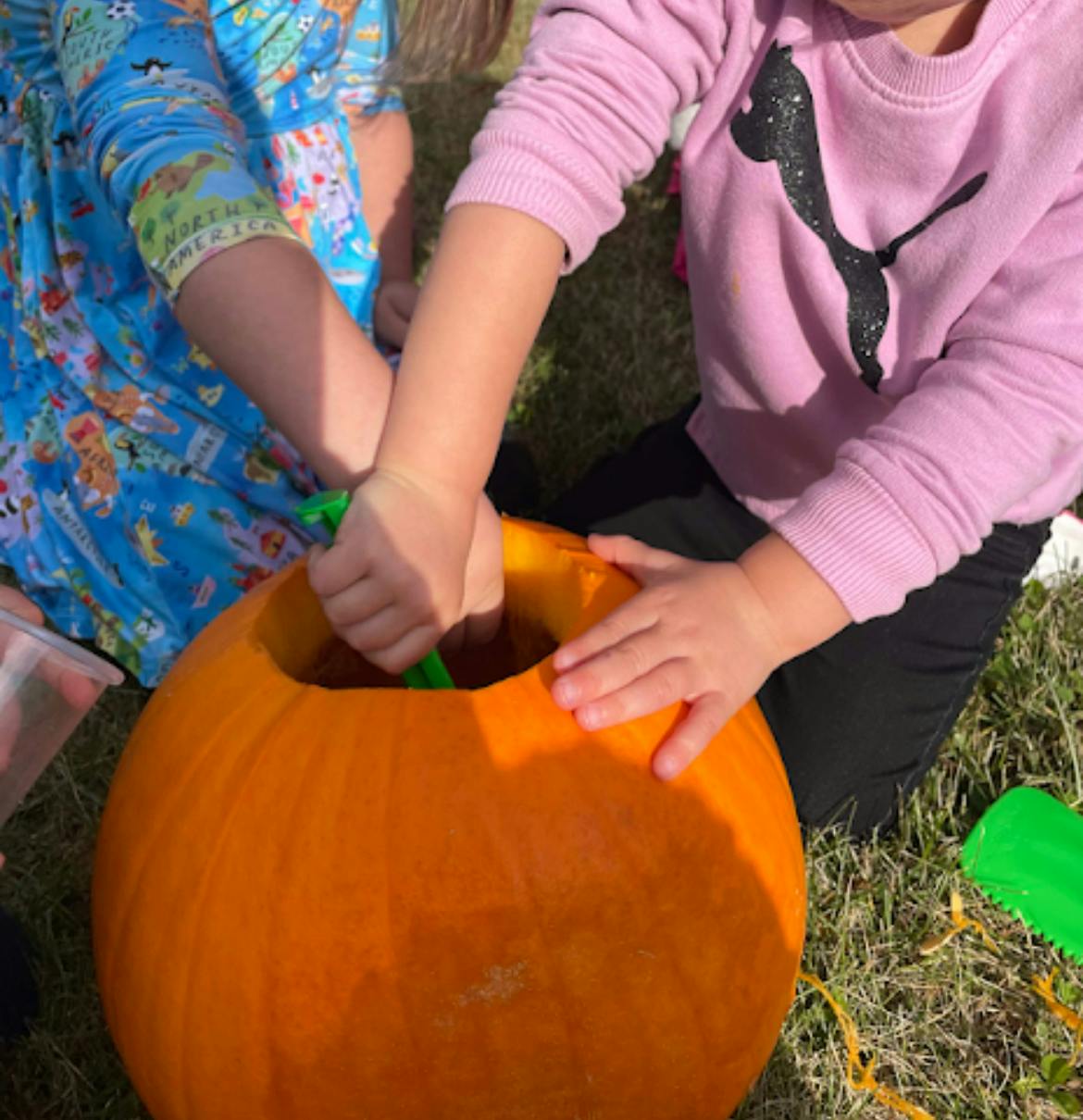 Two children carving a pumpkin