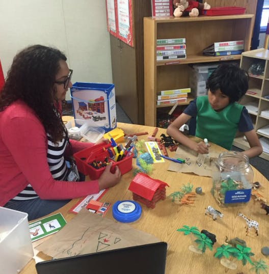 Person and child at a table with craft supplies
