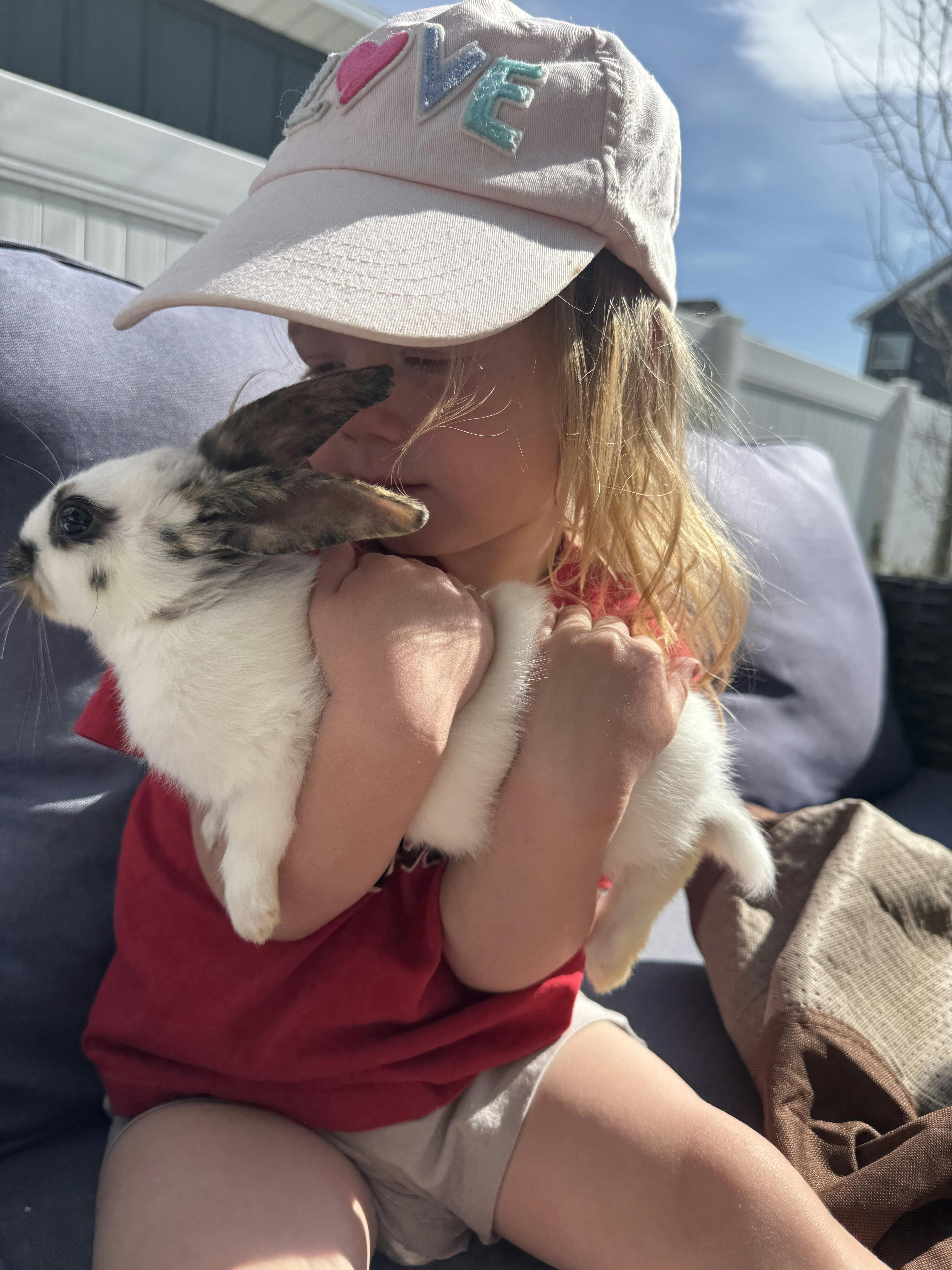 Child in a hat holding a rabbit