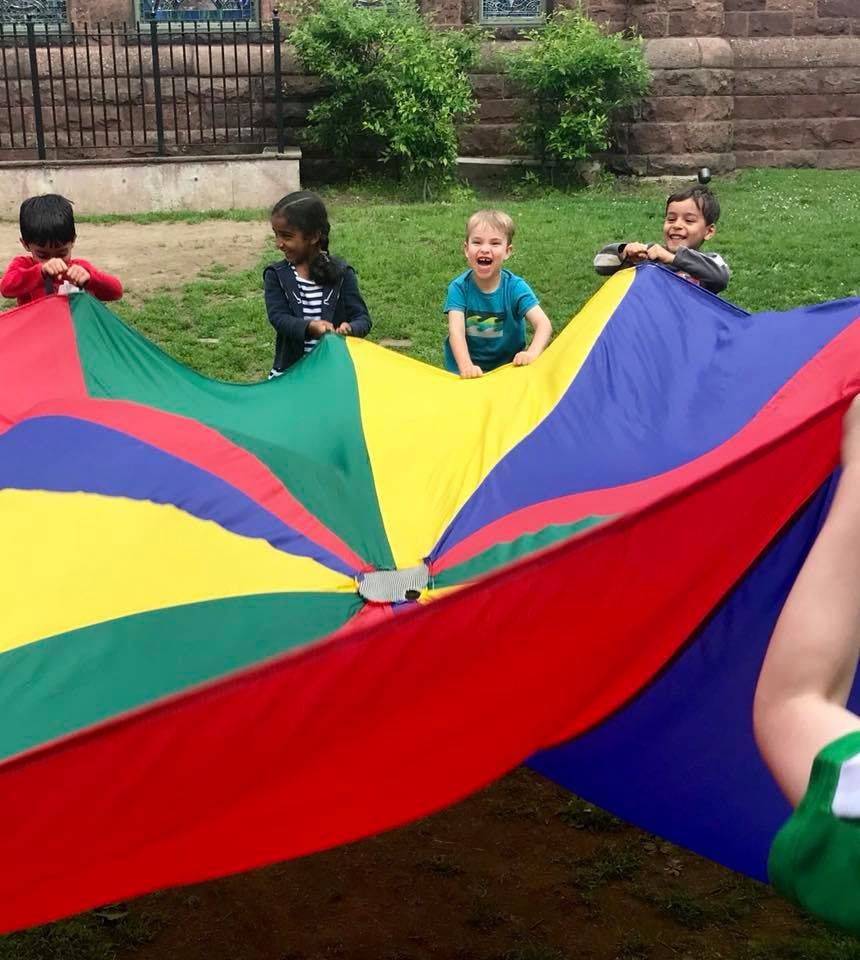 Children playing with a colorful parachute