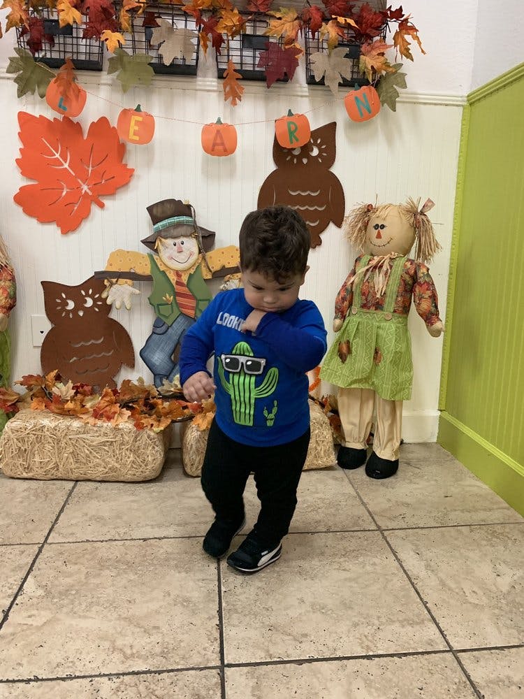 Child standing in front of fall decorations