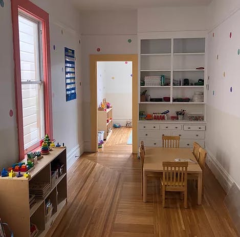 Classroom with small table and chairs, shelves with toys and books