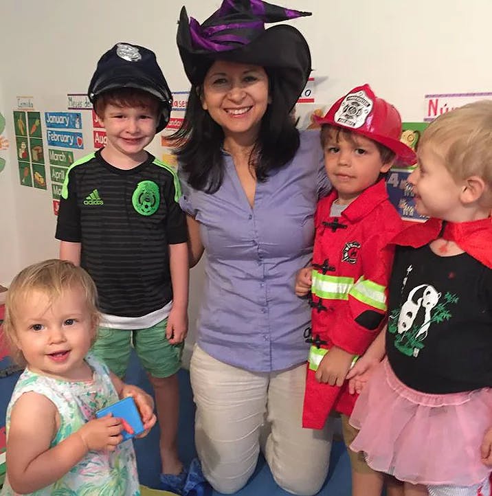 Person in witch hat with three children in costumes and one child in a dress