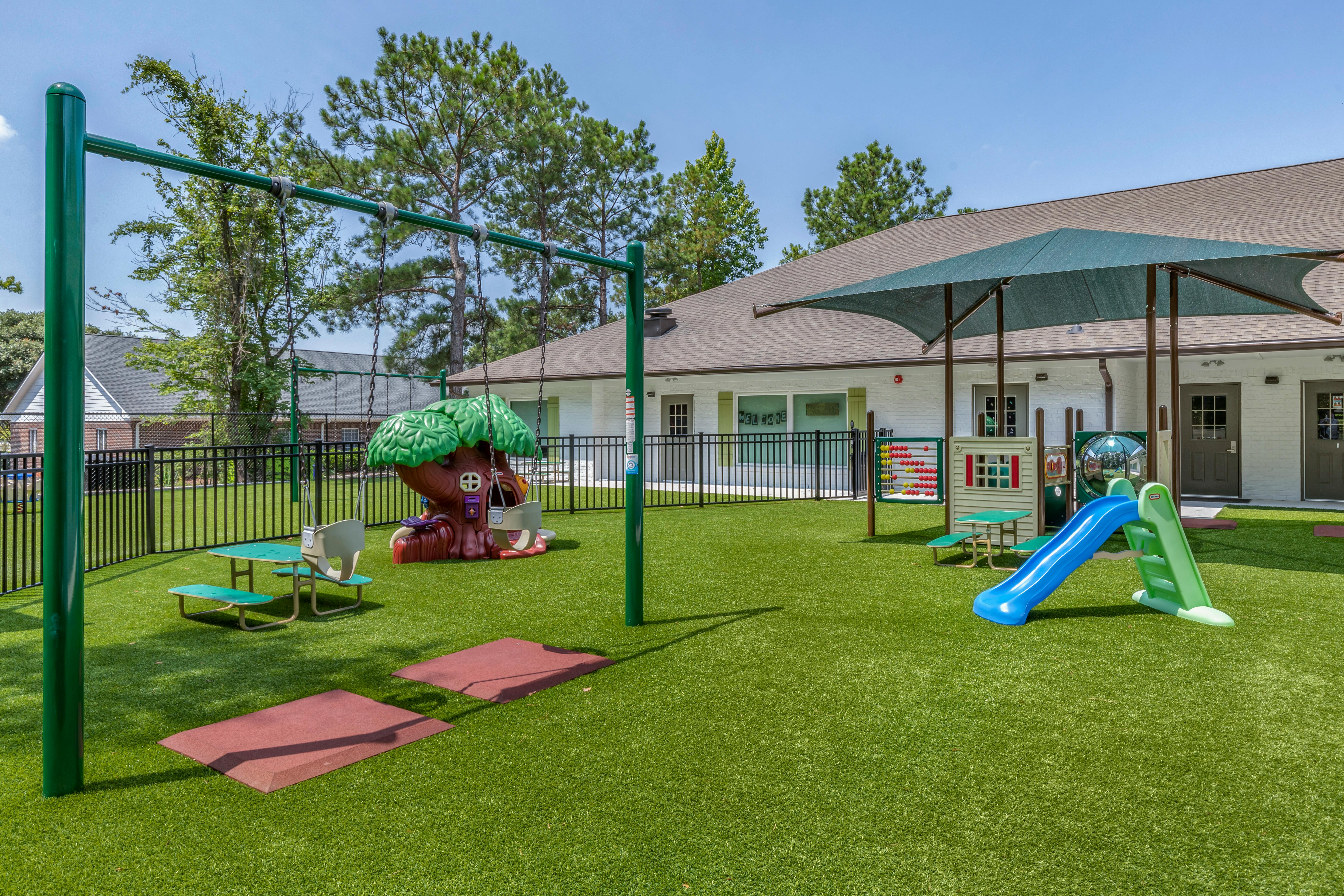 Playground with swings, slides, abacus, picnic table, and treehouse