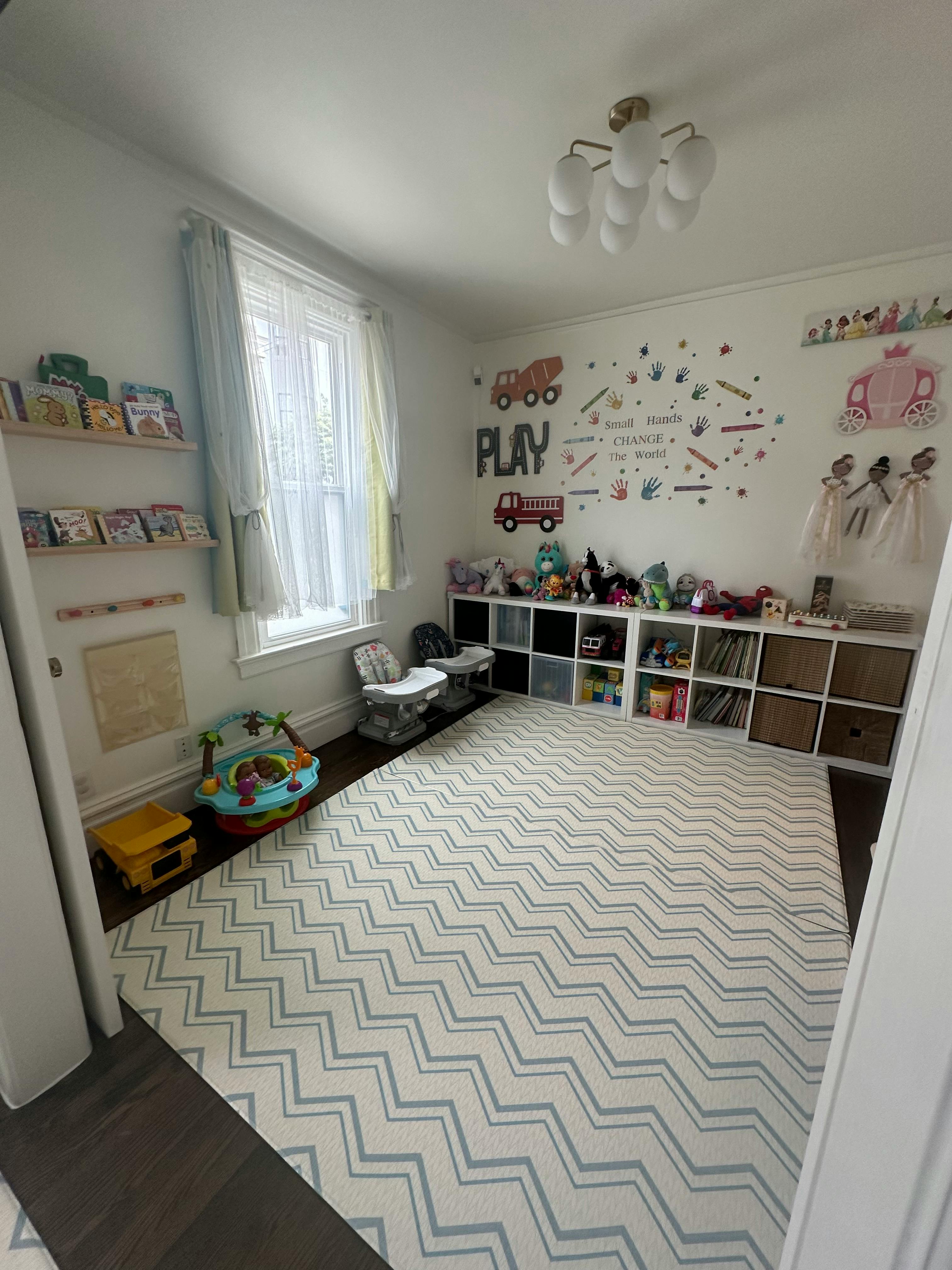 Playroom with a chevron rug, toy shelves, and wall decor