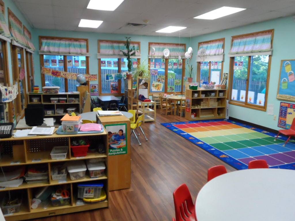 Classroom with a rainbow rug and small tables