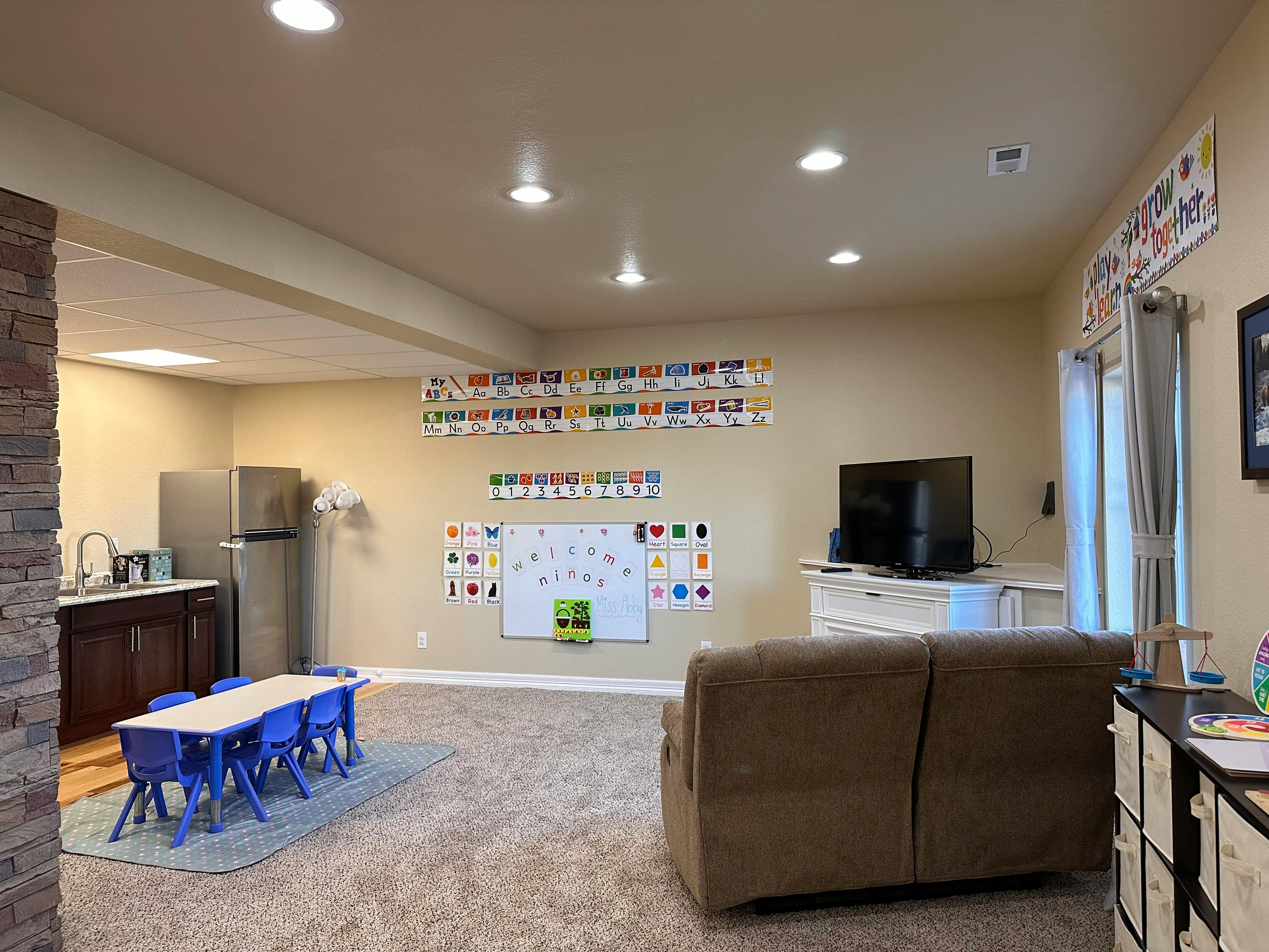 Playroom with small blue table and chairs, whiteboard, and sofa