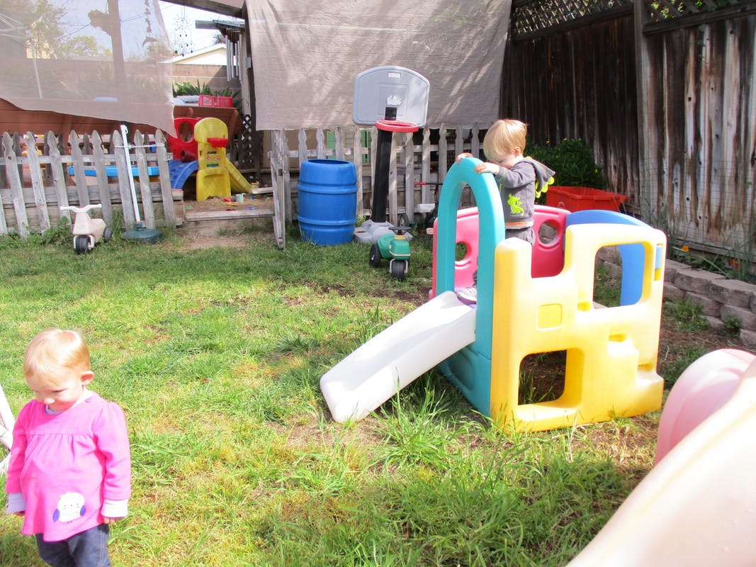 Child standing on a colorful play structure with a slide