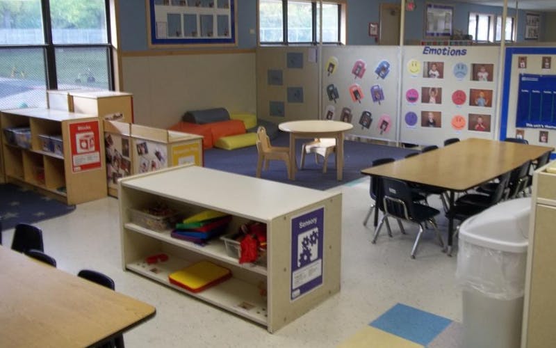 Classroom with tables, chairs, shelving units, and an "Emotions" board