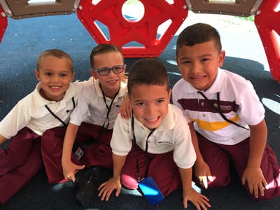 Four children in school uniforms posing together