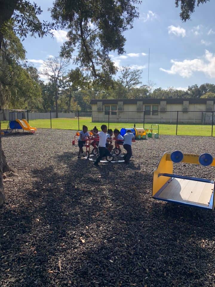 Children playing on tricycles on a playground