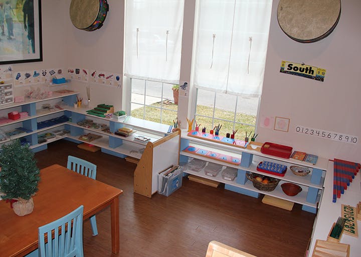 Classroom with shelves of learning materials, tables, and chairs