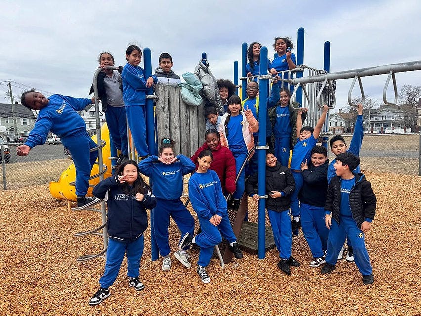Group of children and teens playing on a playground structure