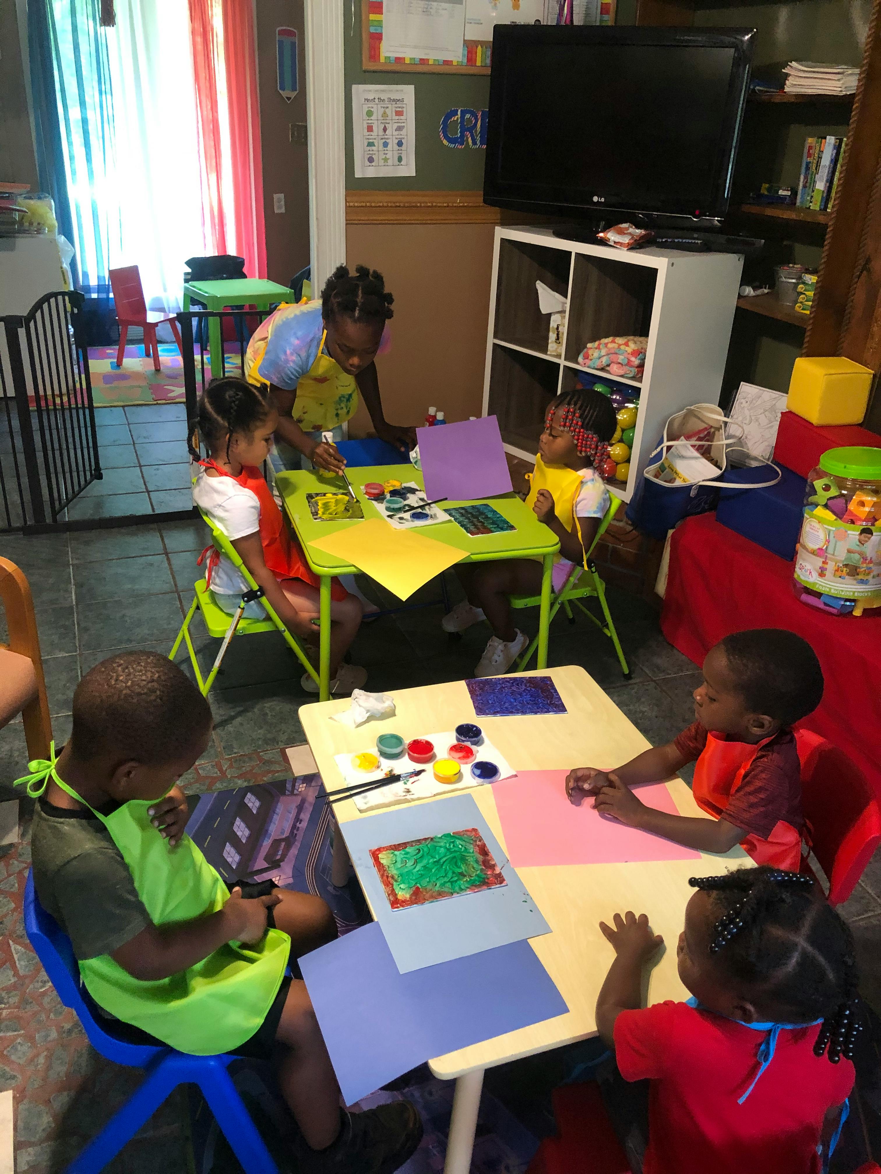 Children doing arts and crafts at small tables in a classroom