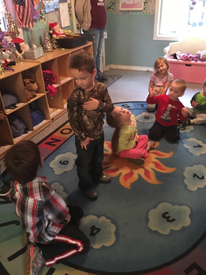 Children on a rug with a sun design