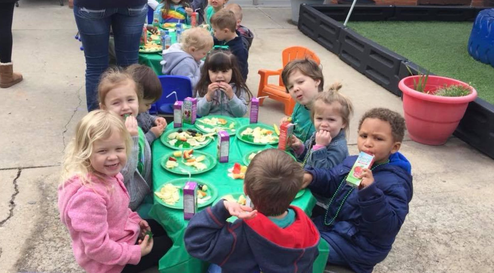 Children eating at a table outdoors