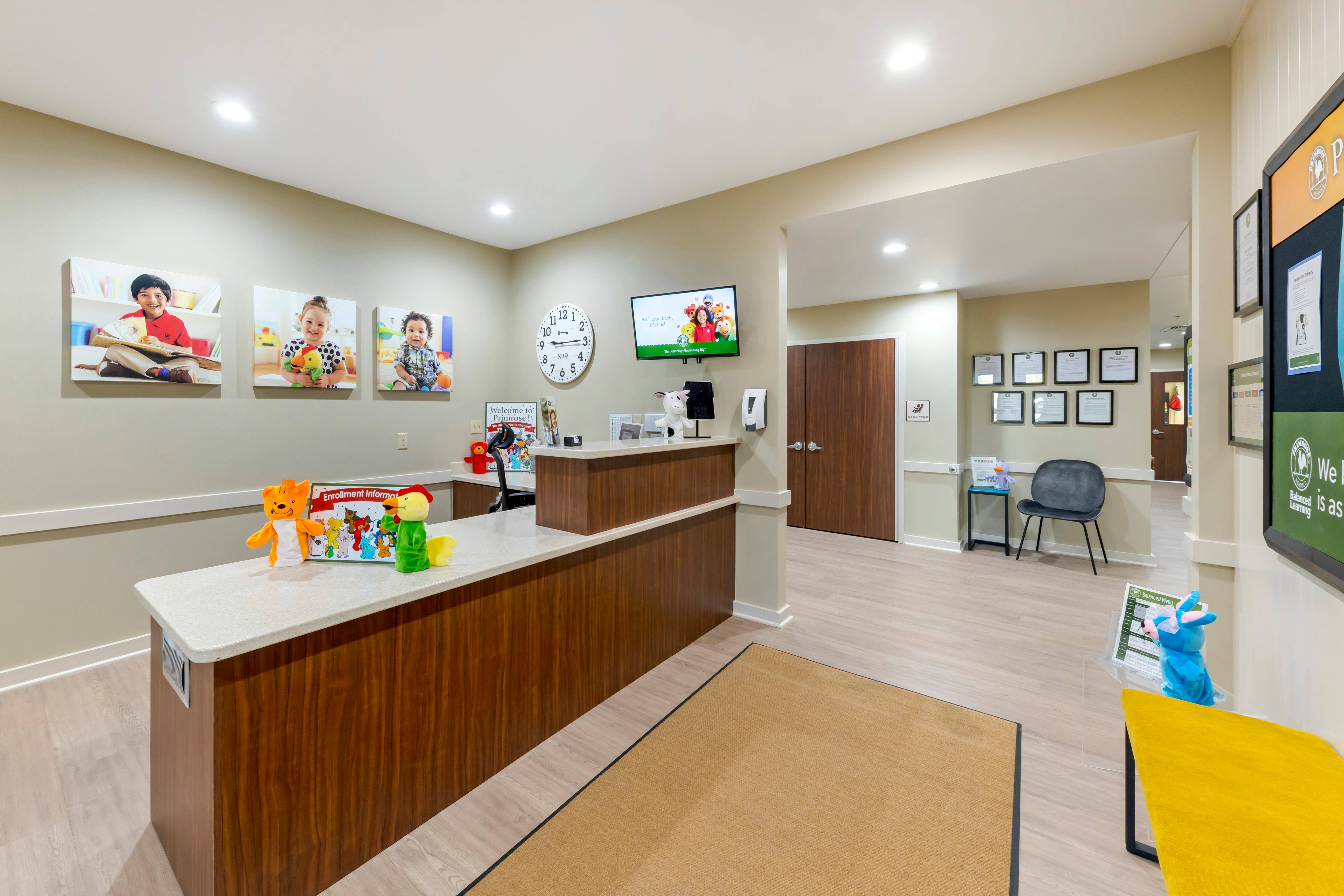 Reception desk with child artwork and images, waiting area with chairs