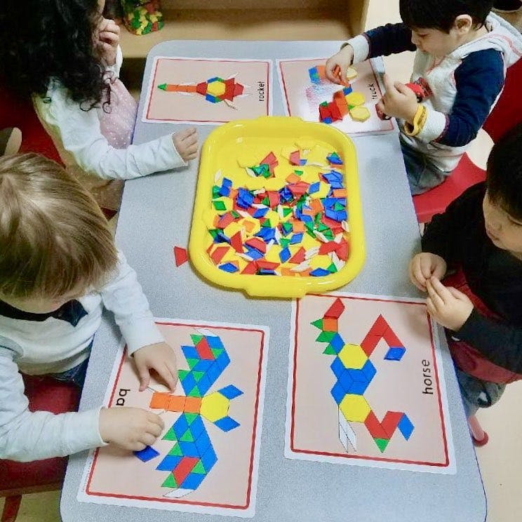 Children playing with colorful geometric shapes on a table