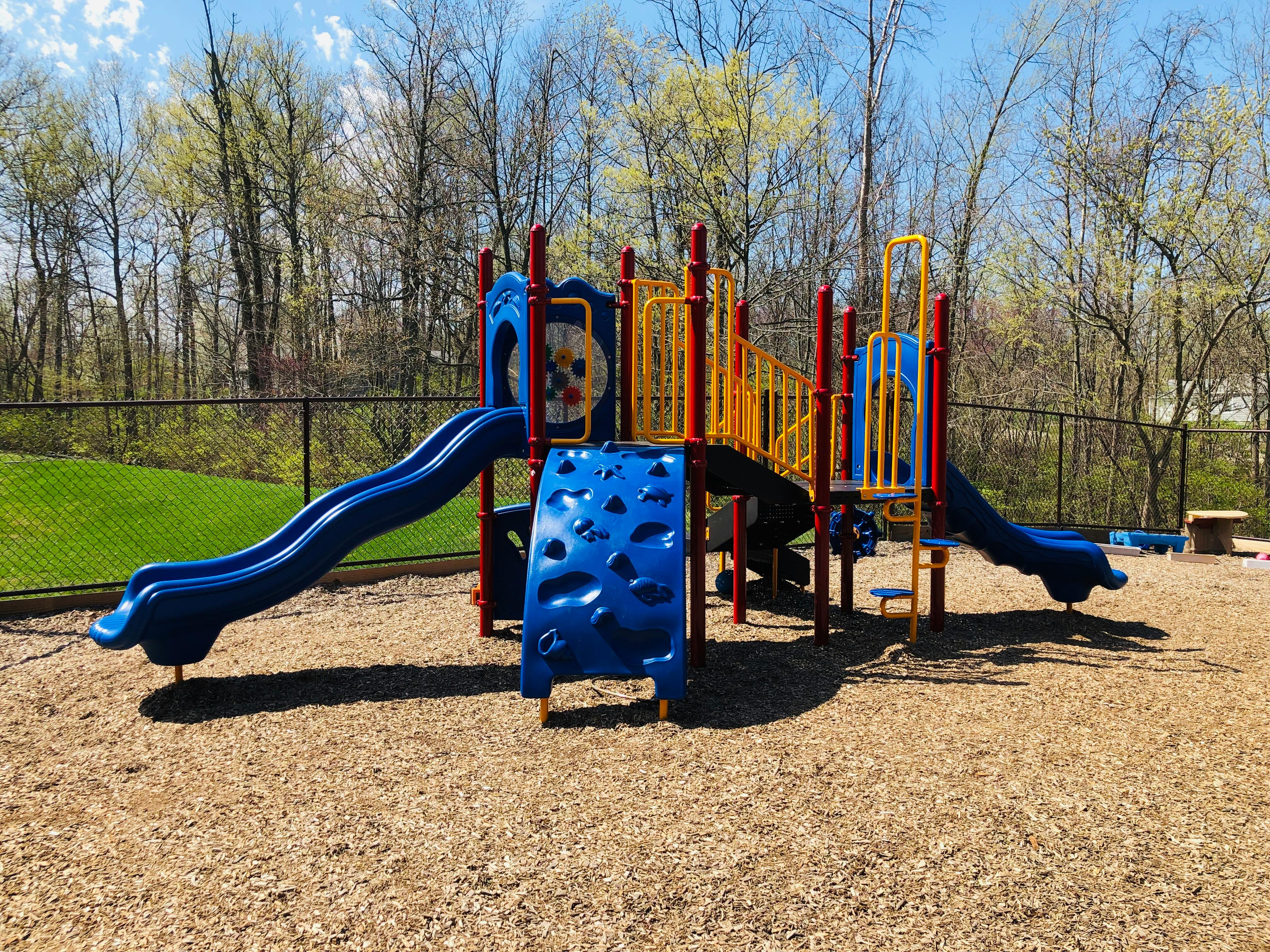 Playground structure with slides and climbing wall