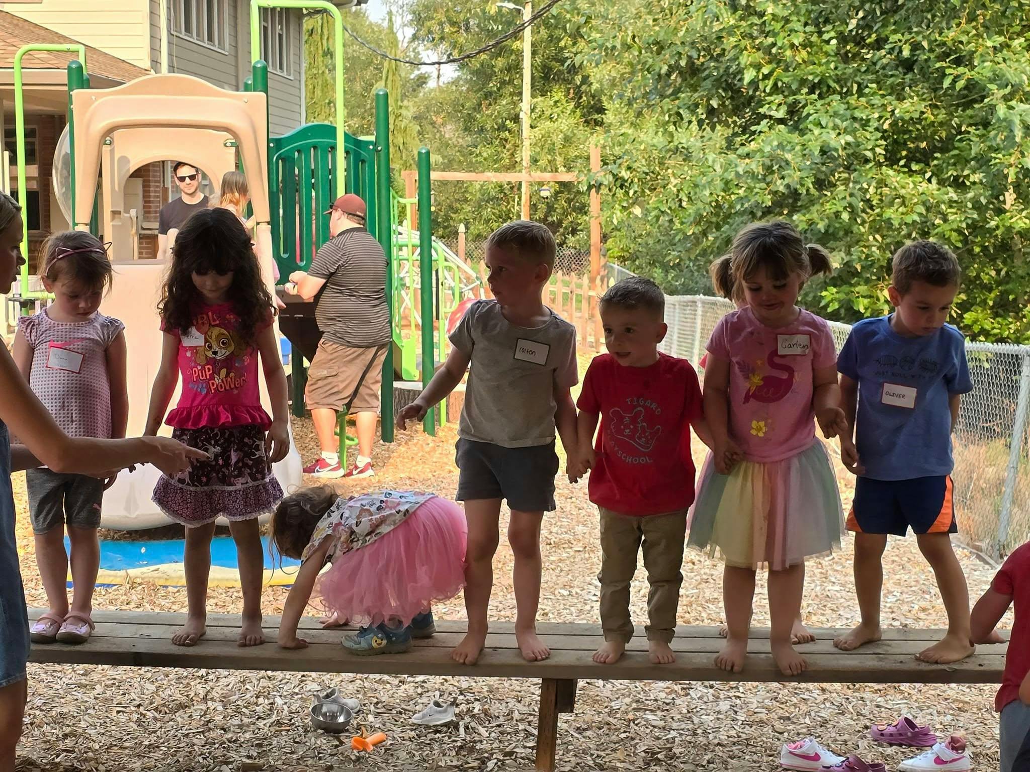 Children standing on a wooden beam on a playground