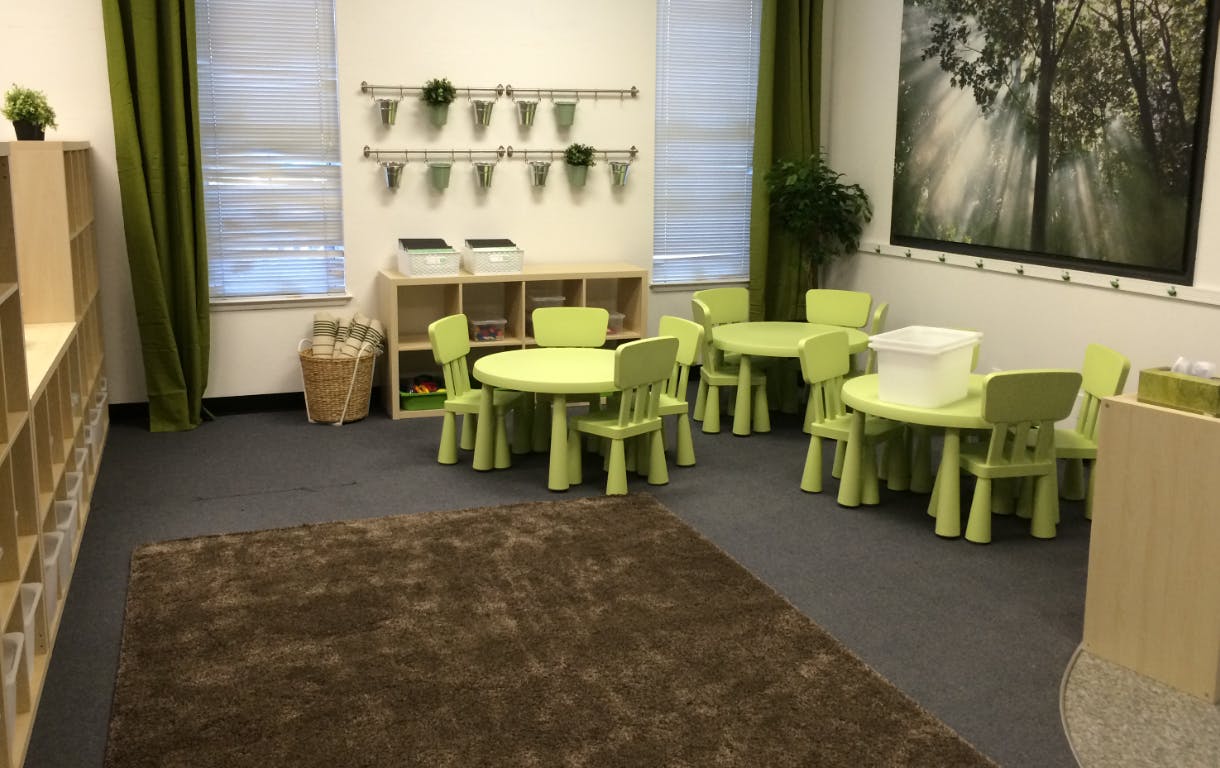 Classroom with small green tables and chairs