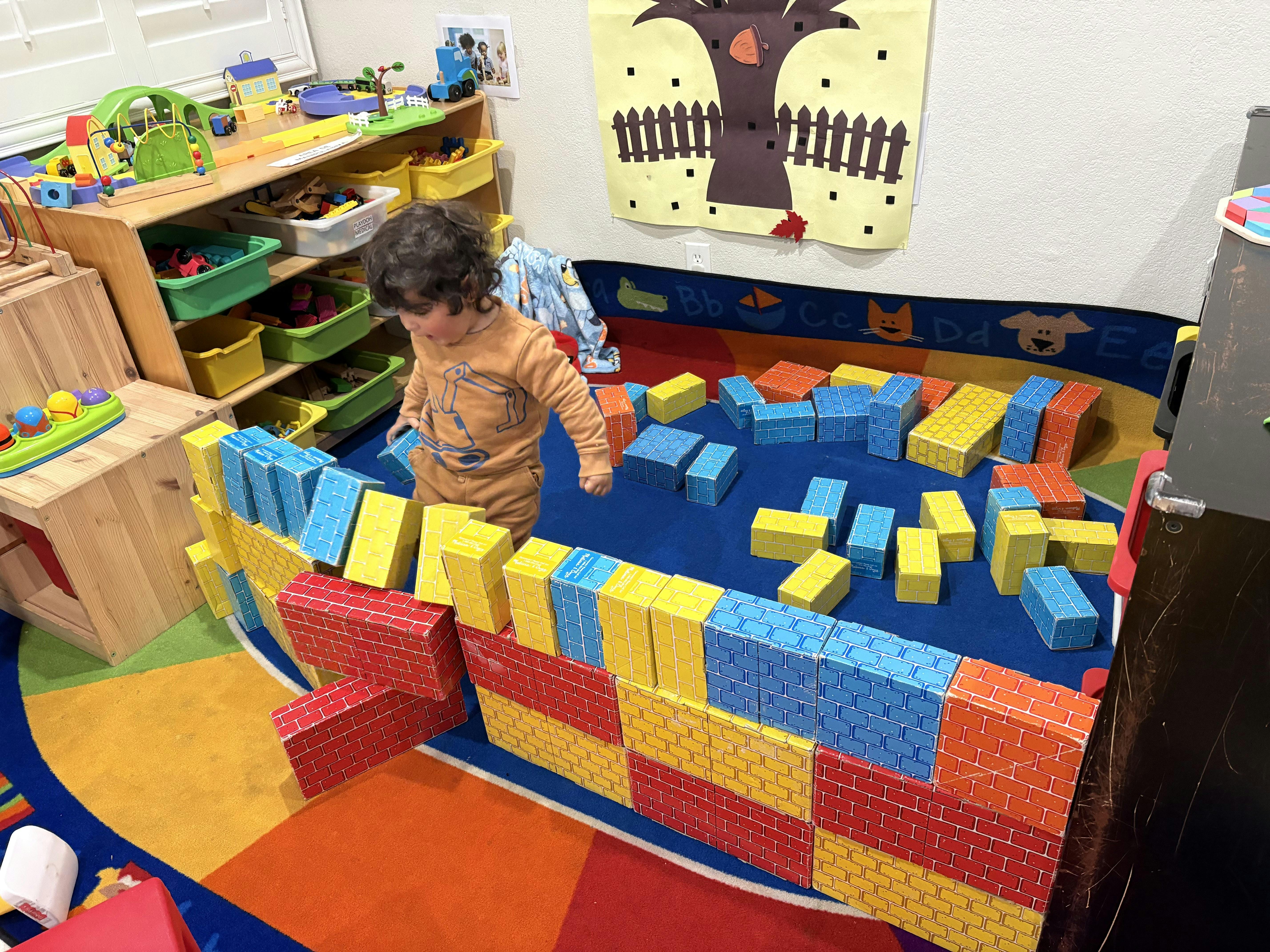 Child playing with colorful building blocks on a rug