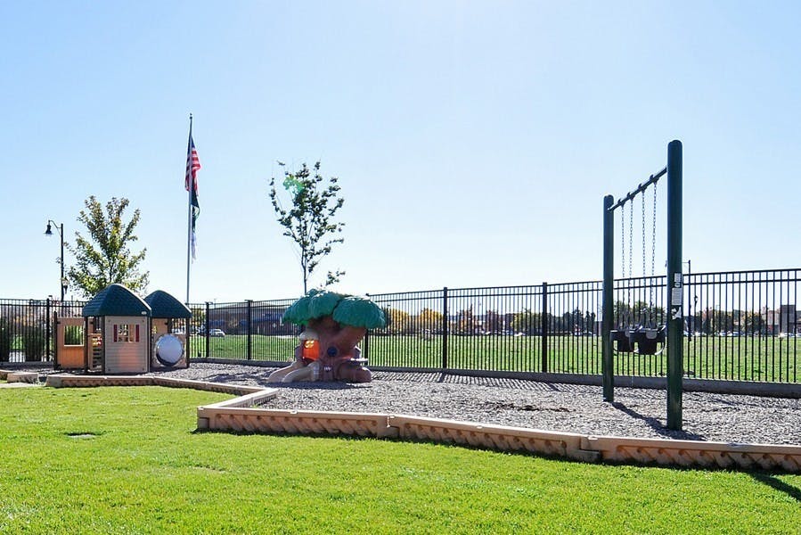 Playground with swings, playhouse, and tree-shaped climbing structure