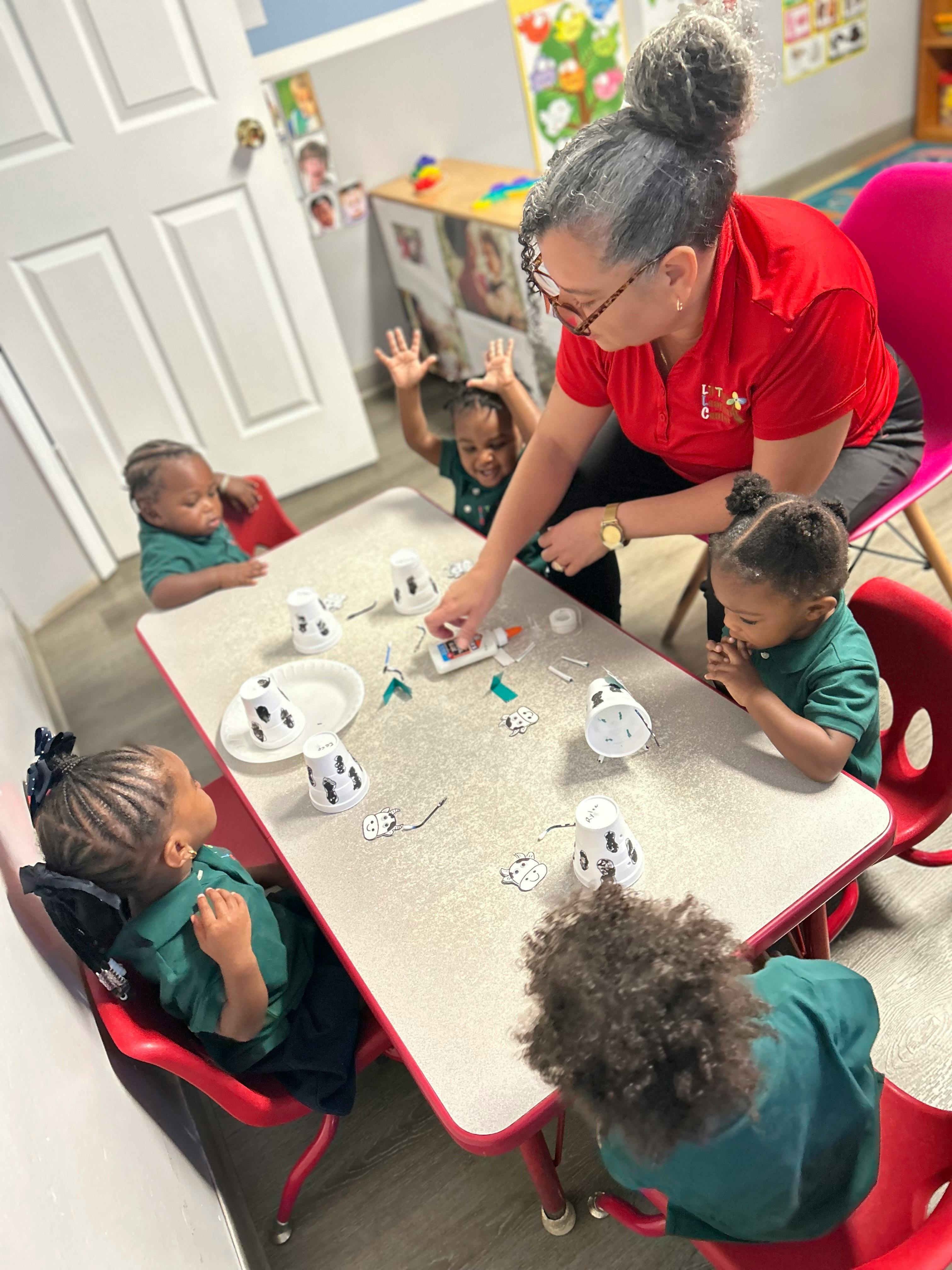Adult and multiple children at a table doing an activity