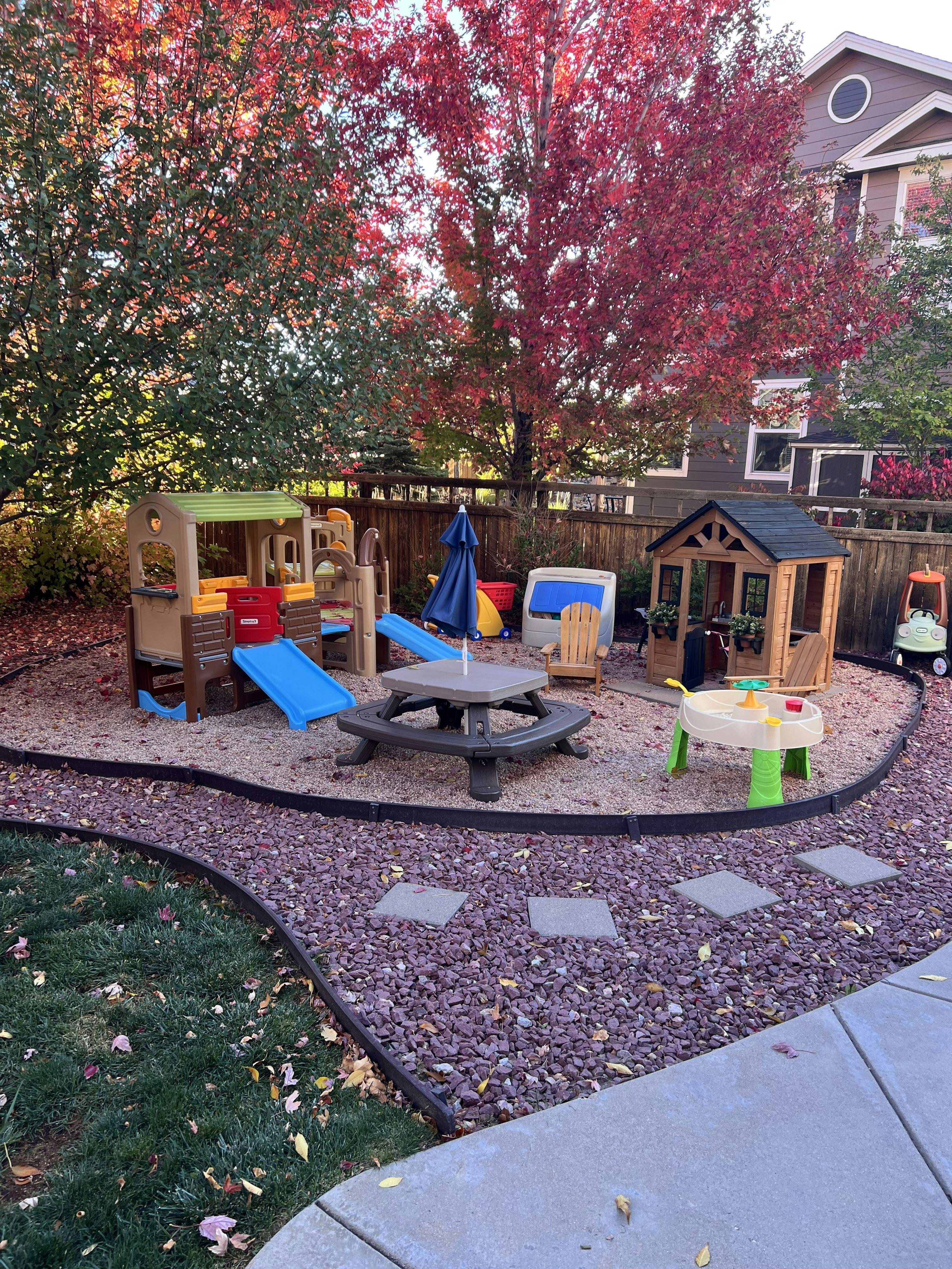 Outdoor play area with playhouses, slides, and a picnic table