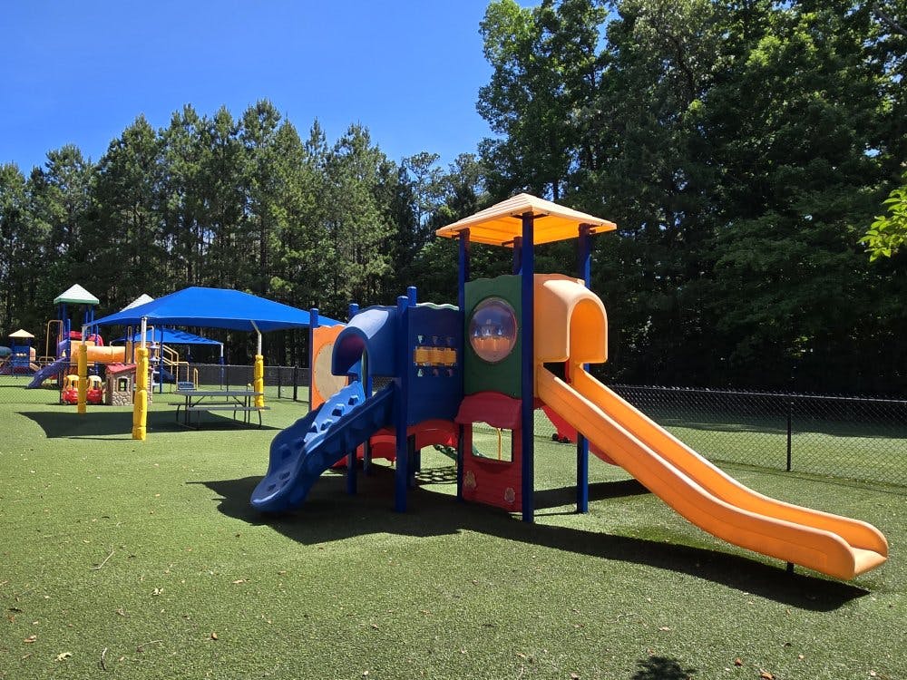 Colorful playground with multiple slides on green turf