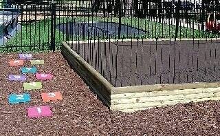 Raised garden bed with colorful stepping stones