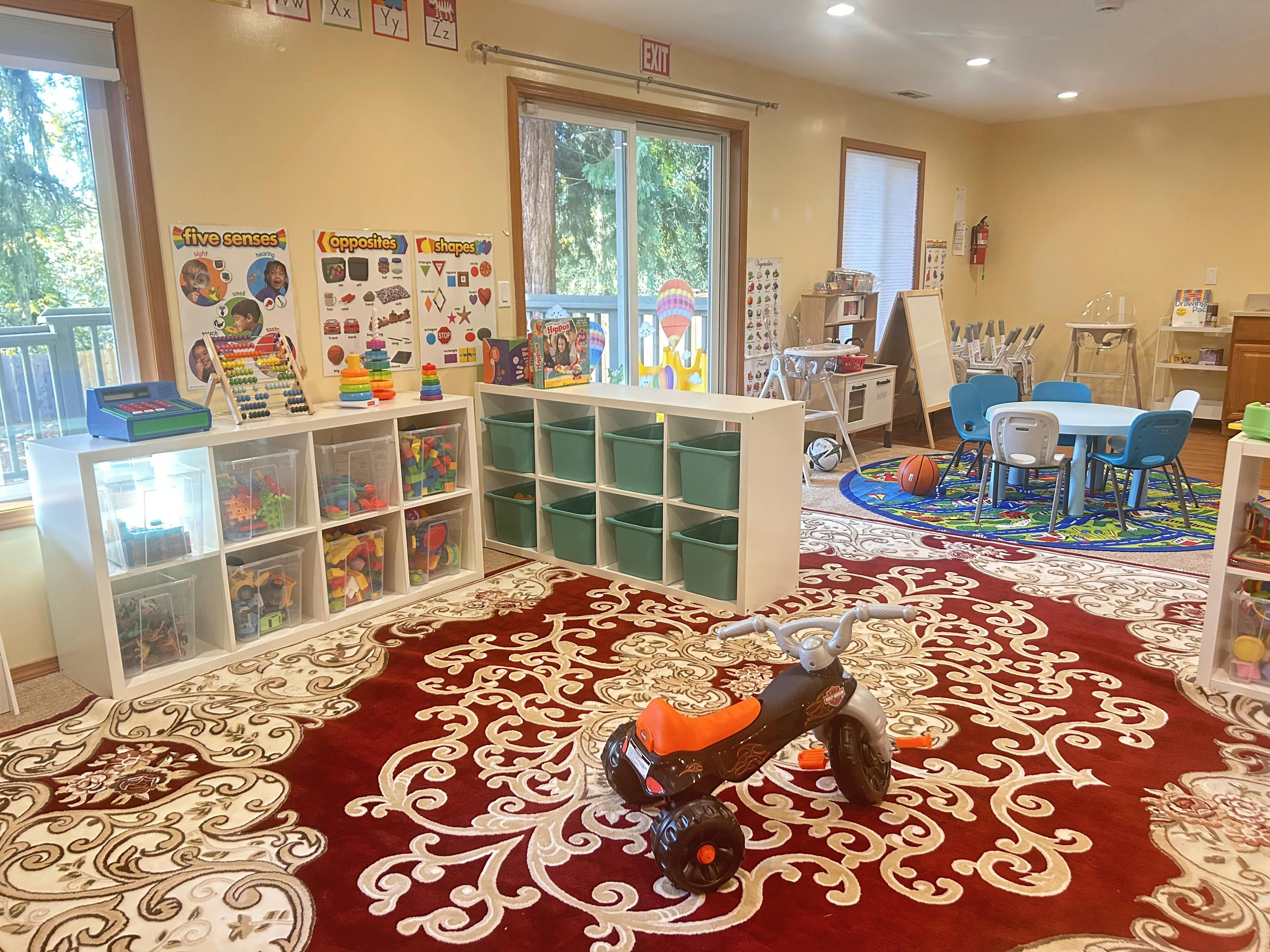 Playroom with toy storage, small tables and chairs, and a toy motorcycle